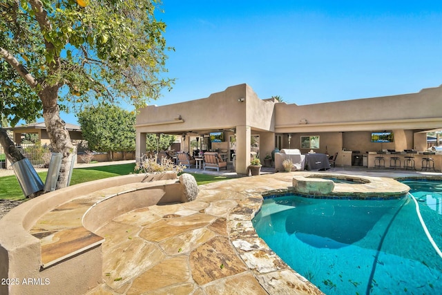 view of pool with outdoor dry bar, a pool with connected hot tub, fence, a patio area, and area for grilling