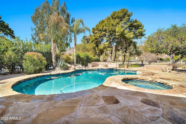 pool with an in ground hot tub and a patio