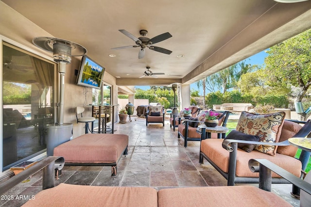 view of patio / terrace featuring an outdoor living space, ceiling fan, and fence