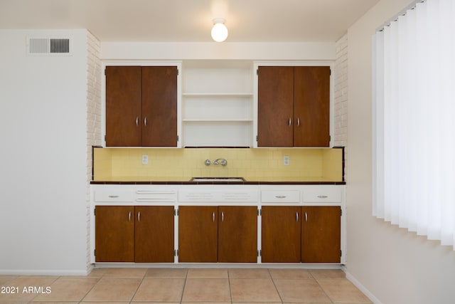 kitchen featuring sink, backsplash, and light tile patterned floors