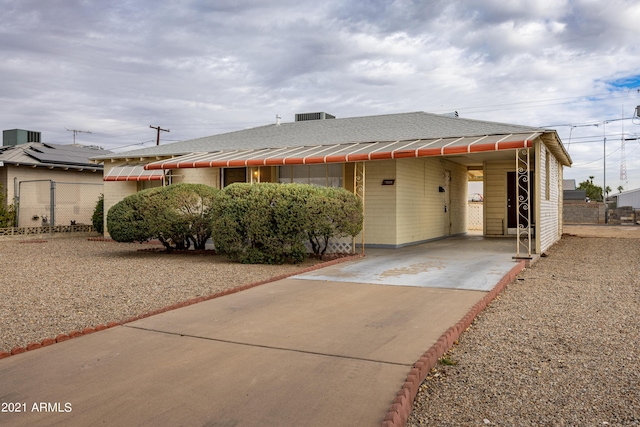 view of front of house featuring cooling unit and a carport