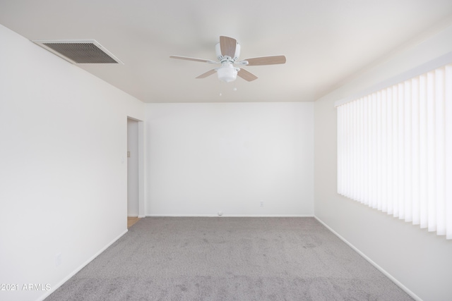 spare room featuring light colored carpet and ceiling fan