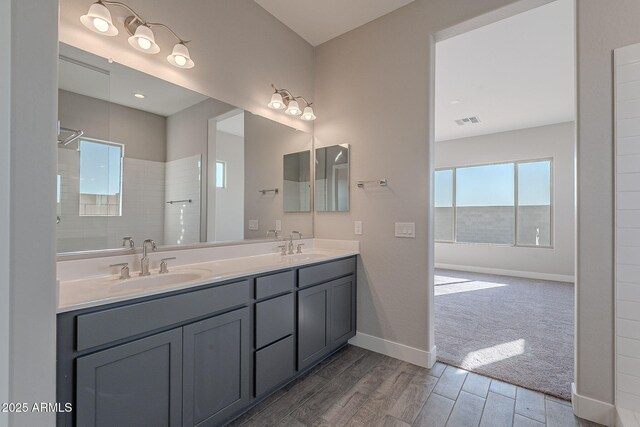 bathroom featuring a shower and vanity