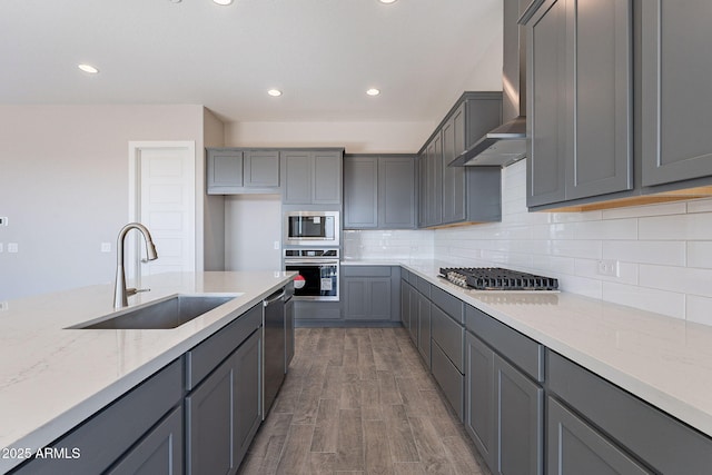 kitchen featuring gray cabinets, sink, wall chimney exhaust hood, and stainless steel appliances