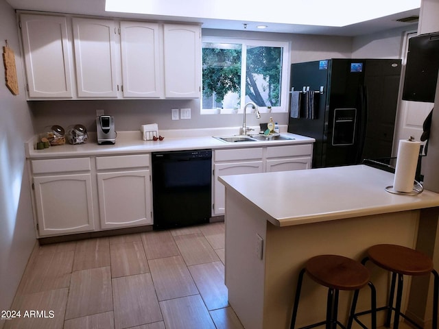 kitchen with black appliances, a kitchen breakfast bar, white cabinetry, and sink