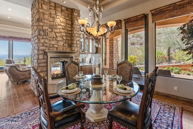 11550 E Paradise Ln, Scottsdale, AZ 85255 - dining area featuring wood-type flooring, a chandelier, a stone fireplace, and recessed lighting