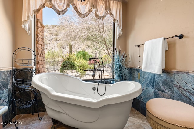 11550 E Paradise Ln, Scottsdale, AZ 85255 - bathroom featuring tile walls, wainscoting, plenty of natural light, and a freestanding tub