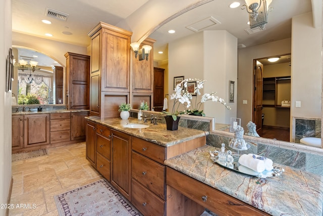 11550 E Paradise Ln, Scottsdale, AZ 85255 - full bathroom featuring two vanities, stone tile flooring, and recessed lighting
