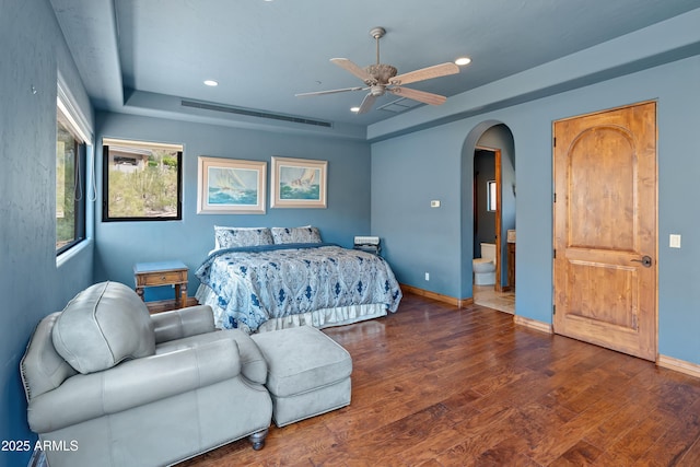 11550 E Paradise Ln, Scottsdale, AZ 85255 - bedroom featuring a tray ceiling, arched walkways, wood finished floors, recessed lighting, and baseboards