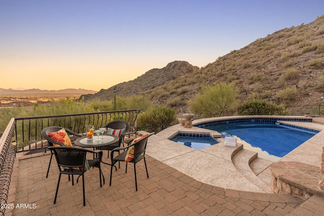 11550 E Paradise Ln, Scottsdale, AZ 85255 - pool at dusk featuring a mountain view, a patio, and a pool with connected hot tub