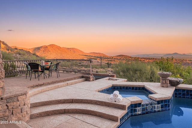 11550 E Paradise Ln, Scottsdale, AZ 85255 - pool at dusk with an in-ground hot tub, a mountain view, a patio, and an outdoor pool