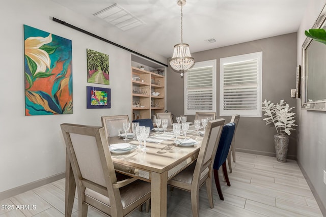 20784 W Minnezona Ave, Buckeye, AZ 85396 - dining room featuring a chandelier, baseboards, and wood finish floors
