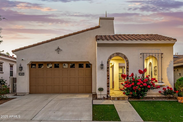 20784 W Minnezona Ave, Buckeye, AZ 85396 - view of front of home with an attached garage, concrete driveway, stucco siding, and a tile roof