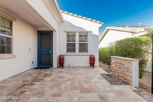 20784 W Minnezona Ave, Buckeye, AZ 85396 - doorway to property featuring stucco siding and a patio area