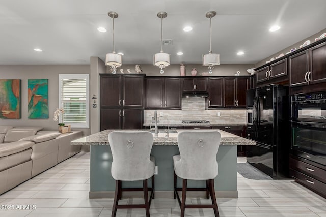 20784 W Minnezona Ave, Buckeye, AZ 85396 - kitchen with black appliances, open floor plan, decorative backsplash, a sink, and dark brown cabinets