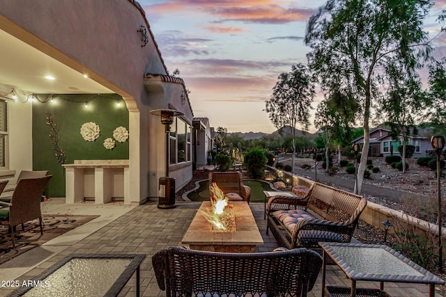 20784 W Minnezona Ave, Buckeye, AZ 85396 - patio terrace at dusk with a patio and an outdoor living space with a fire pit
