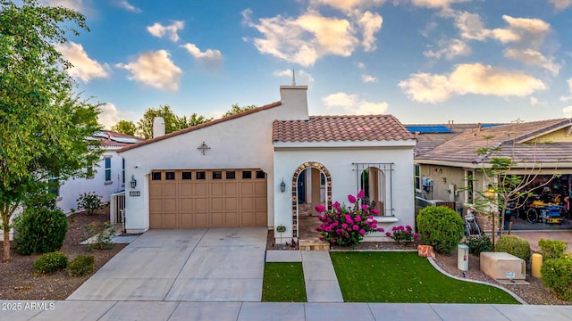 20784 W Minnezona Ave, Buckeye, AZ 85396 - mediterranean / spanish-style house with an attached garage, a tile roof, stucco siding, driveway, and a chimney