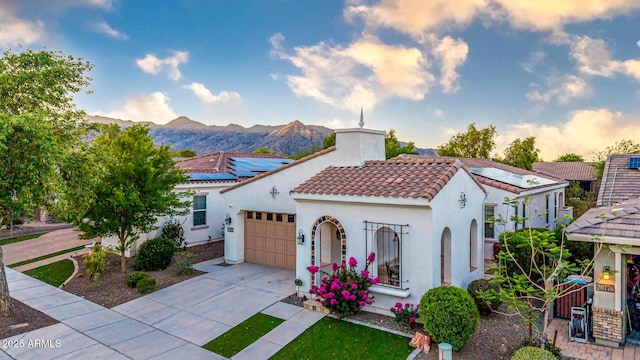 20784 W Minnezona Ave, Buckeye, AZ 85396 - mediterranean / spanish-style home with a garage, a tiled roof, driveway, a mountain view, and stucco siding