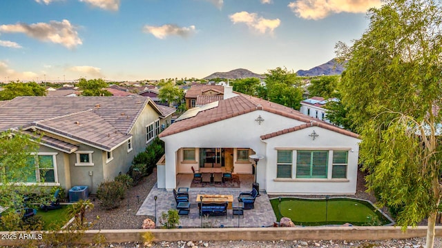 20784 W Minnezona Ave, Buckeye, AZ 85396 - back of house with an area to practice putting, an outdoor hangout area, a patio area, a mountain view, and cooling unit