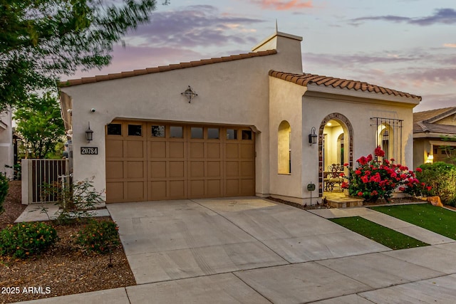 20784 W Minnezona Ave, Buckeye, AZ 85396 - mediterranean / spanish-style home with a garage, a tile roof, concrete driveway, and stucco siding