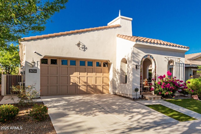 20784 W Minnezona Ave, Buckeye, AZ 85396 - mediterranean / spanish house featuring an attached garage, a tiled roof, stucco siding, and driveway
