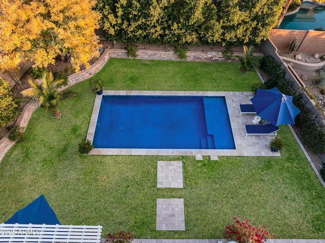 view of swimming pool featuring a lawn