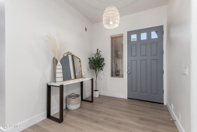 foyer entrance featuring a chandelier and light hardwood / wood-style flooring