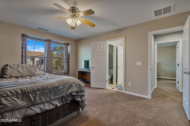 bedroom with ceiling fan, light carpet, and ensuite bathroom