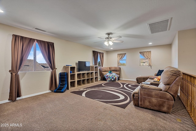 carpeted living room with ceiling fan