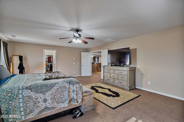 bedroom with ceiling fan, a walk in closet, and carpet floors