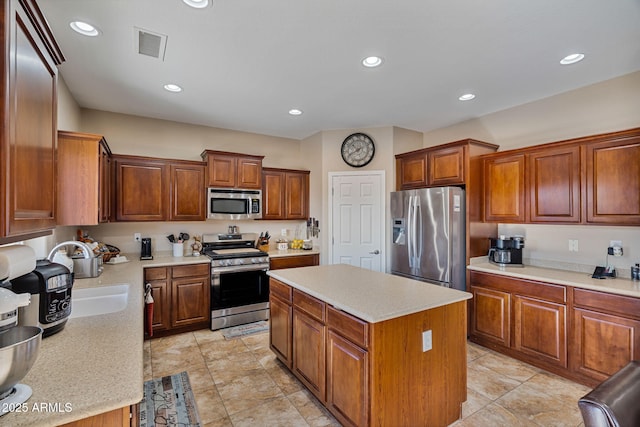 kitchen with light tile patterned floors, stainless steel appliances, sink, and a center island