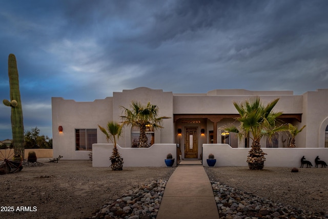 southwest-style home featuring a fenced front yard and stucco siding