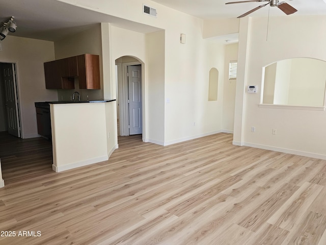 14250 W Wigwam Blvd Unit 1723, Litchfield Park, AZ 85340 - unfurnished living room featuring ceiling fan, arched walkways, and light wood-type flooring