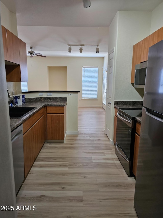 14250 W Wigwam Blvd Unit 1723, Litchfield Park, AZ 85340 - kitchen featuring appliances with stainless steel finishes, ceiling fan, a peninsula, light wood finished floors, and brown cabinets