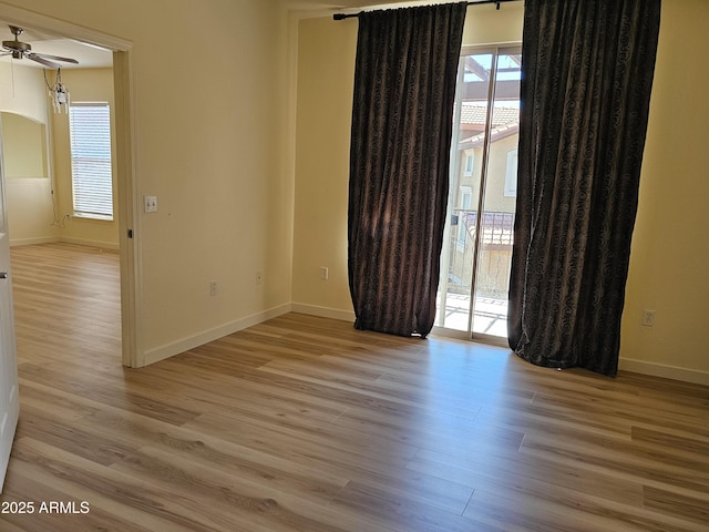 14250 W Wigwam Blvd Unit 1723, Litchfield Park, AZ 85340 - empty room with wood finished floors, ceiling fan, and arched walkways
