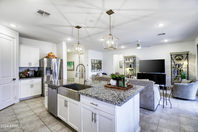 kitchen with pendant lighting, a center island with sink, white cabinets, sink, and stainless steel appliances