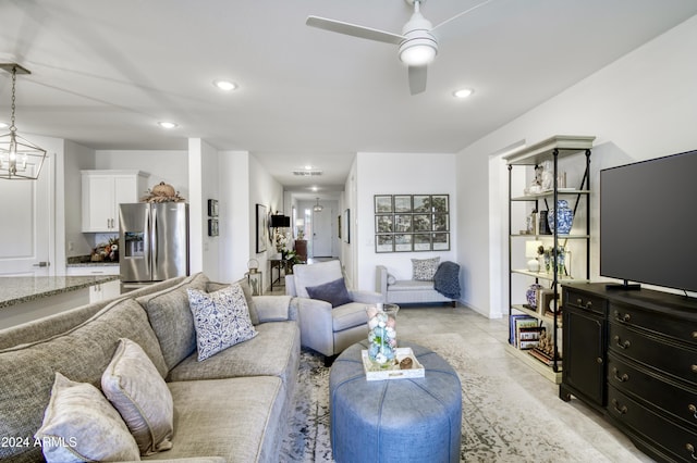 living room featuring ceiling fan with notable chandelier