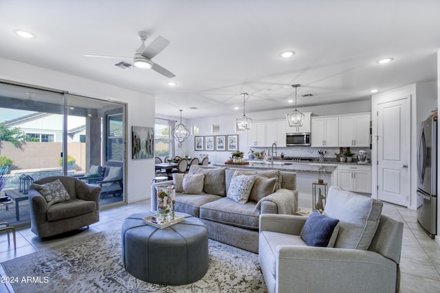 tiled living room featuring ceiling fan and sink