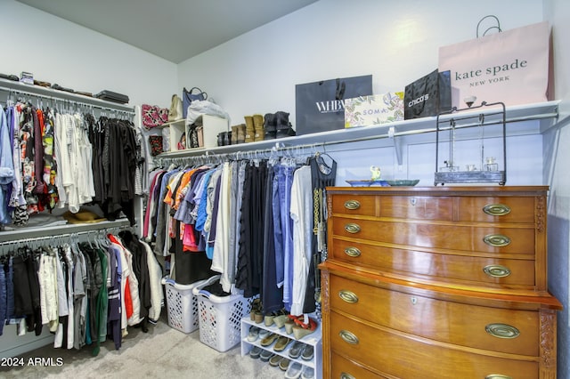 walk in closet featuring light carpet