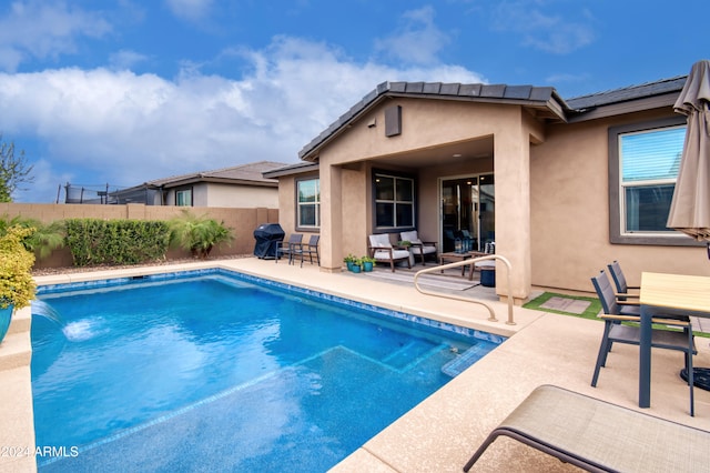 view of pool featuring a patio area, pool water feature, and area for grilling