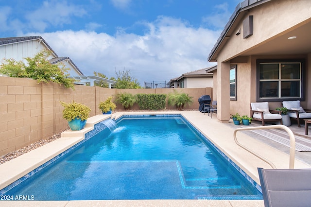 view of swimming pool featuring pool water feature and a patio