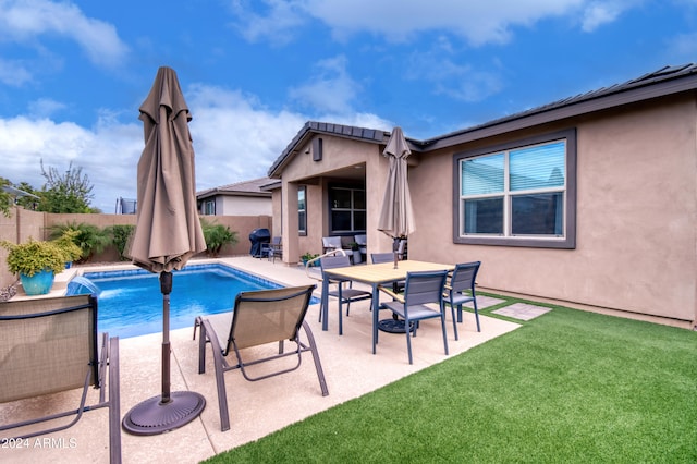 view of swimming pool featuring a yard, pool water feature, and a patio