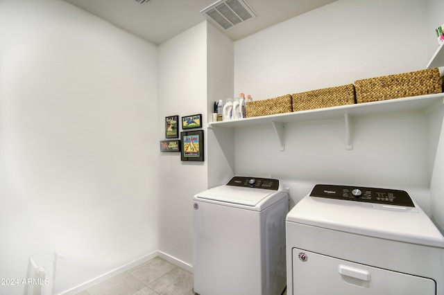 clothes washing area with separate washer and dryer and light tile patterned floors