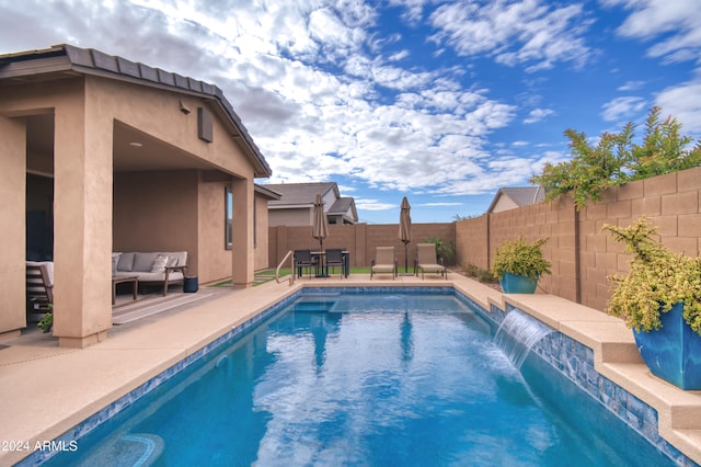 view of swimming pool featuring pool water feature, an outdoor living space, and a patio