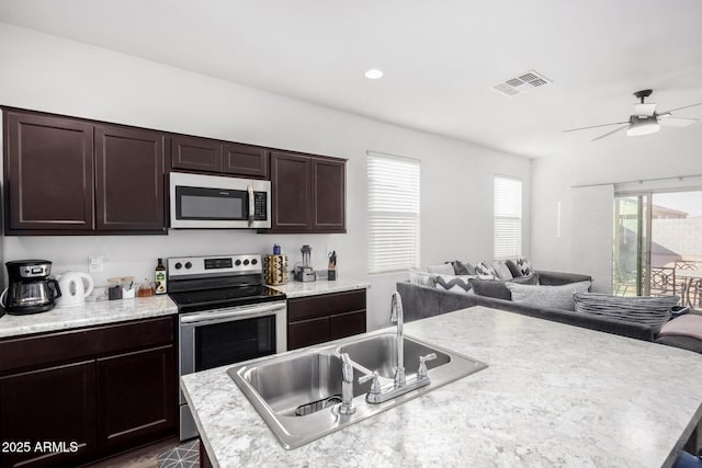 kitchen featuring visible vents, open floor plan, light countertops, stainless steel appliances, and a sink