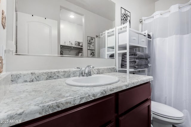 bathroom with toilet, a shower with shower curtain, and vanity