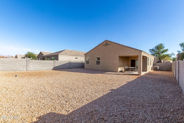 rear view of property featuring a patio, a fenced backyard, and stucco siding