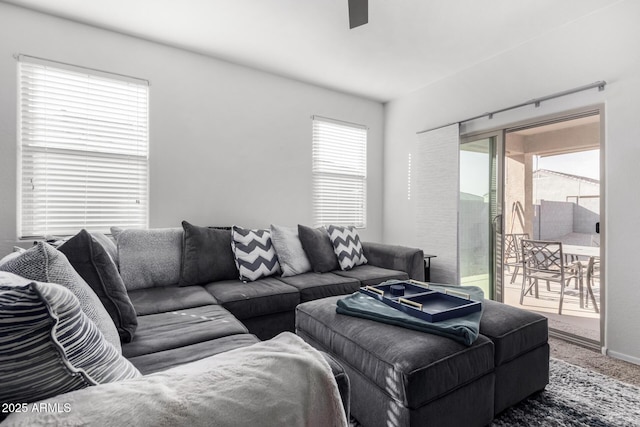 carpeted living area with ceiling fan