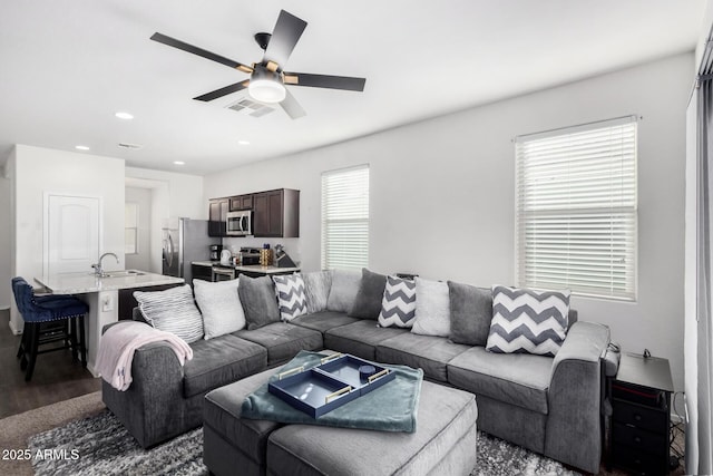 living area with a ceiling fan, recessed lighting, dark wood-style flooring, and visible vents