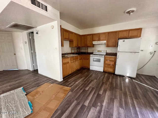 kitchen featuring dark hardwood / wood-style flooring, white appliances, a textured ceiling, and sink